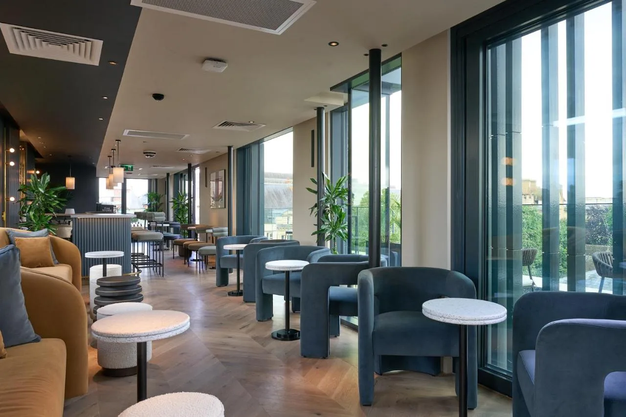 Bright lounge with tables, chairs and large windows at The Store Oxford